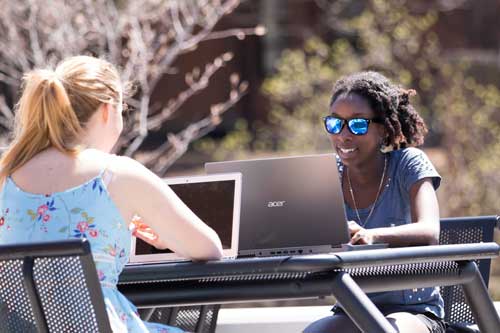 students outside on laptops
