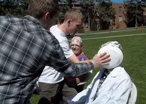two students pieing a professor