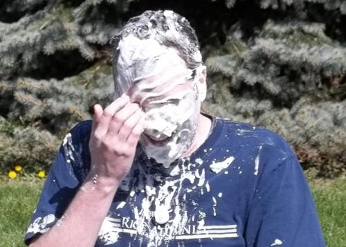 professor wiping pie from his face