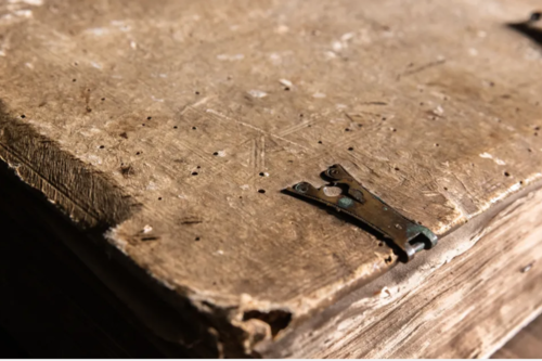 Photo of a book published in the 1500s, with tattered pages and the binding.