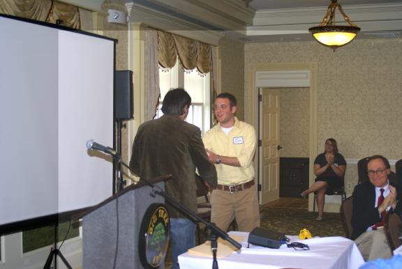 Professor Michael Oberg presents a paper prize to Andrew Gustafson