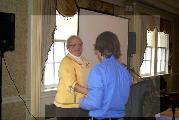 Professor Meg Stolee presents a scholarship award to Thomas Evans