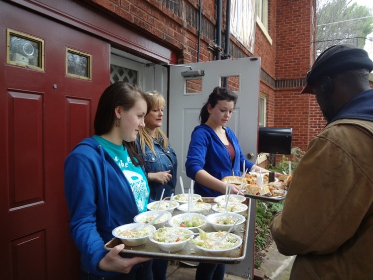 Students and community members serving food to residents in an Atlanta community.