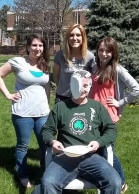 female students standing around pied professor