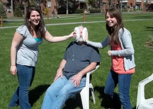 sitting professor getting pied twice by posing girls