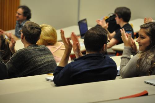 Students clapping in lecture hall