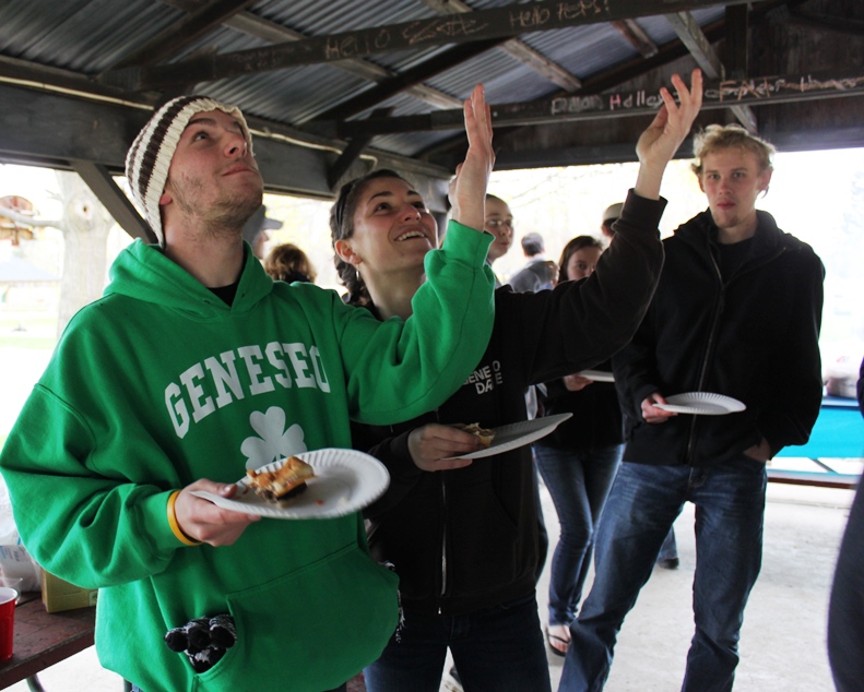 PRISM Math Club: Students eat food with arms extended towards sky
