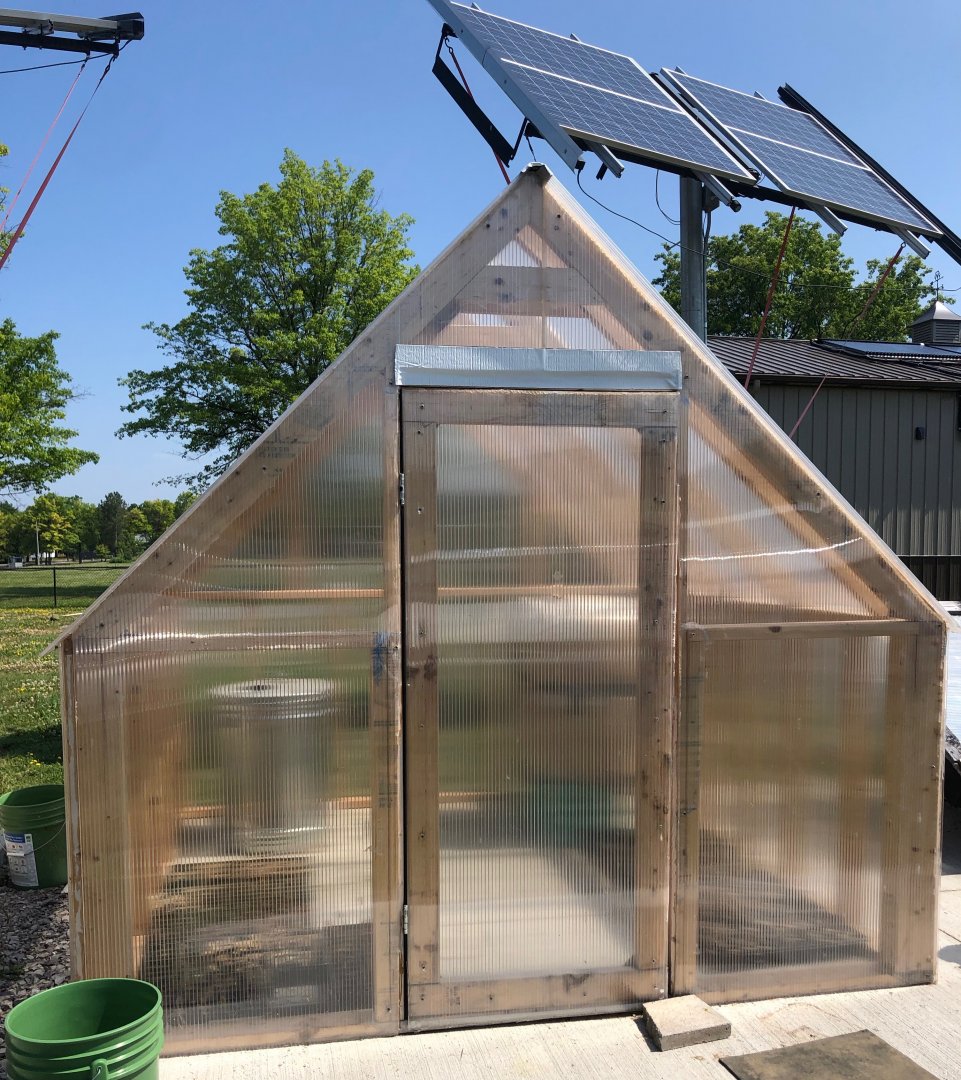 The outside of the greenhouse, solar arrays visible above.