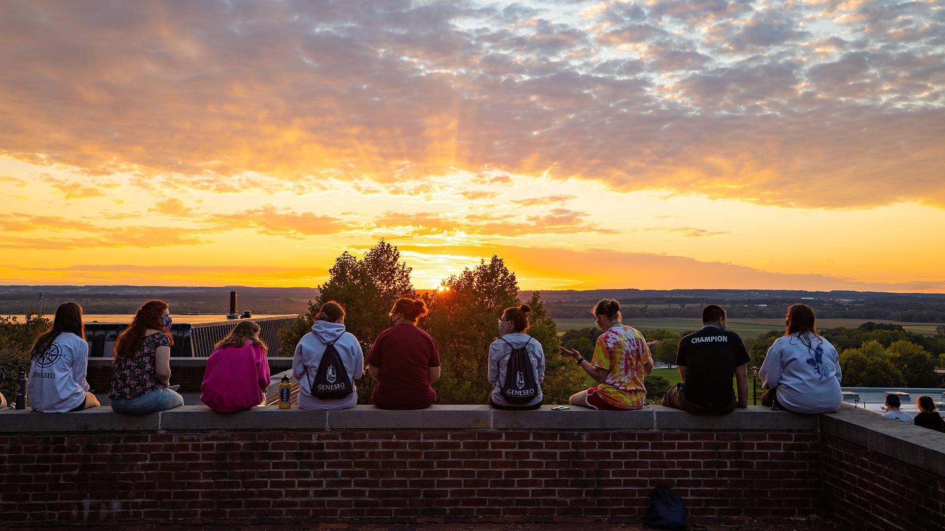 students looking over the valley at sunset