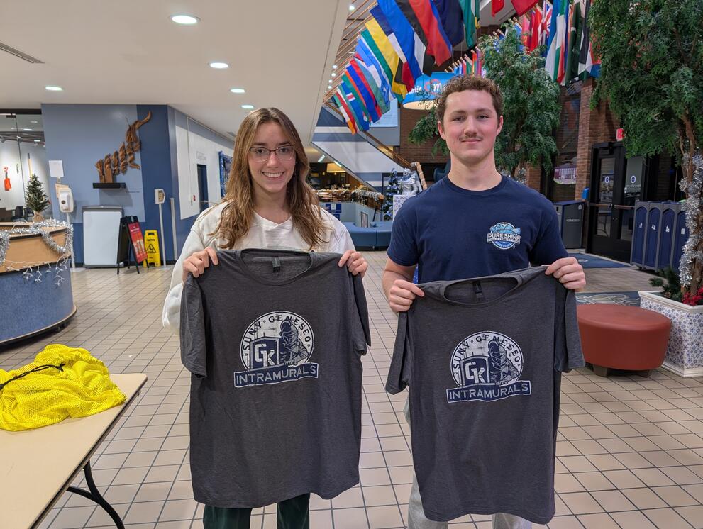 2 ping pong champions holding gray intramural t-shirts.