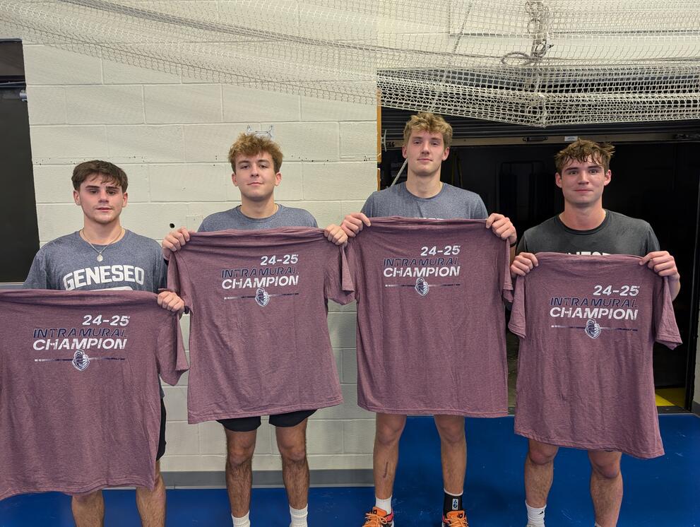 4 basketball champions holding purple intramural t-shirts.