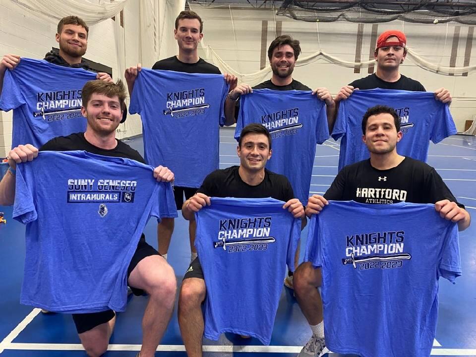 Group of arena football champions holding blue intramural shirts.