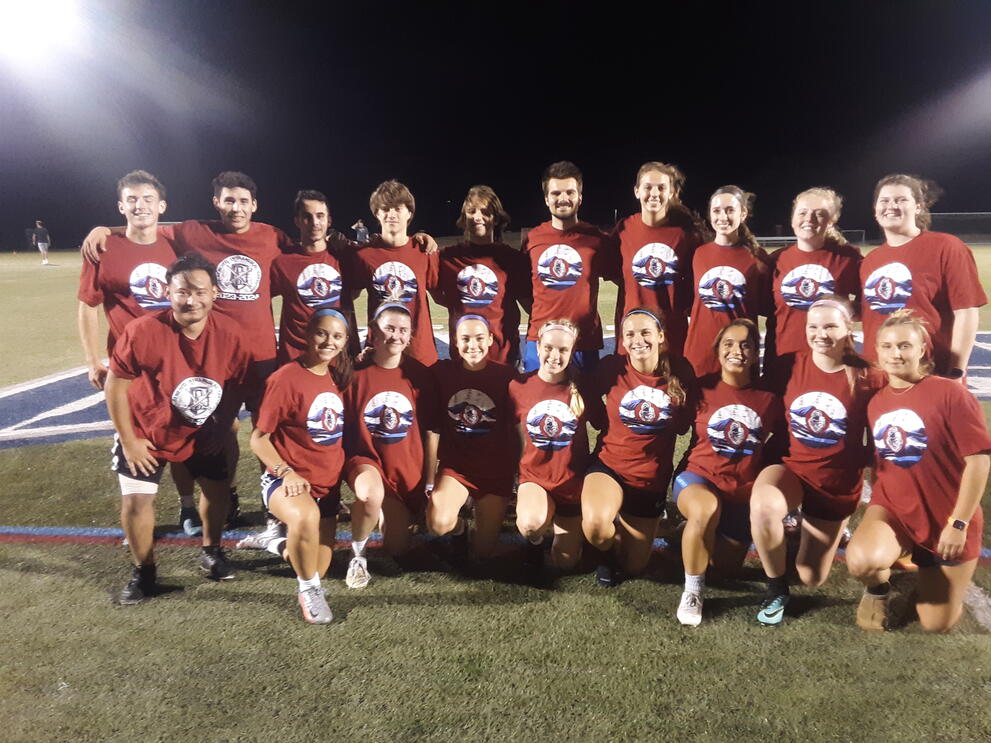 Eighteen soccer champions on the field wearing red uniforms