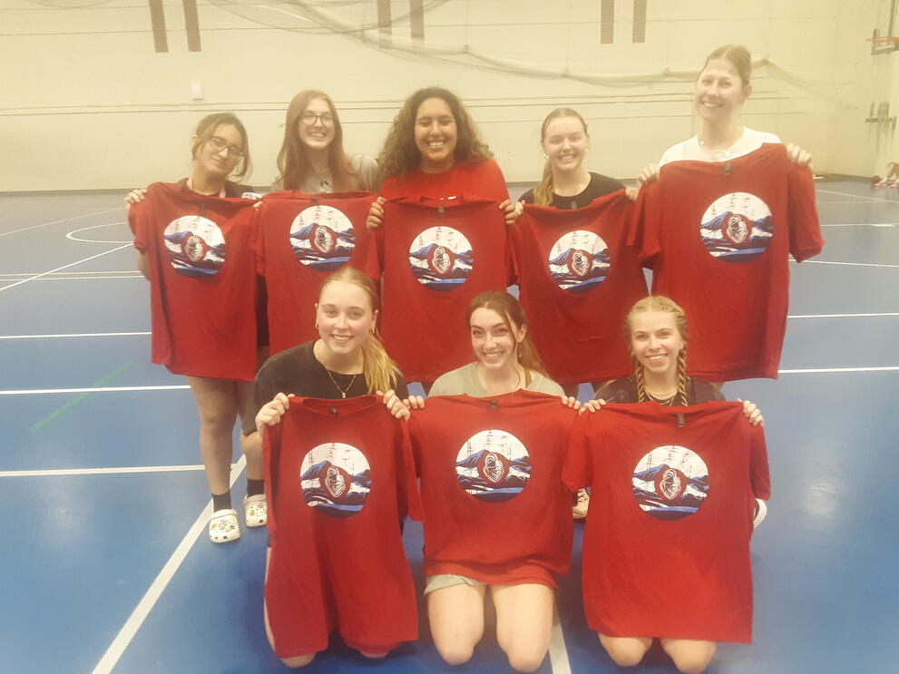 Eight volleyball champions holding red uniforms