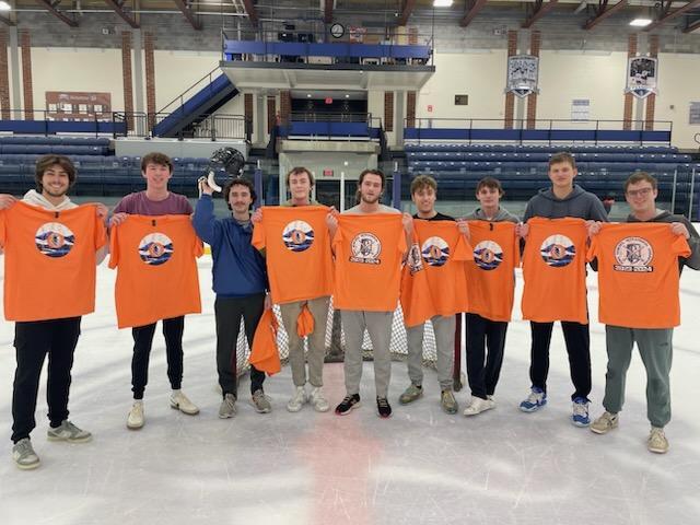 Nine broomball champions wearing orange uniforms