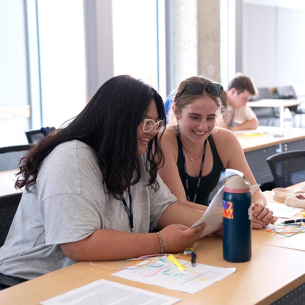 Two students discussing a paper