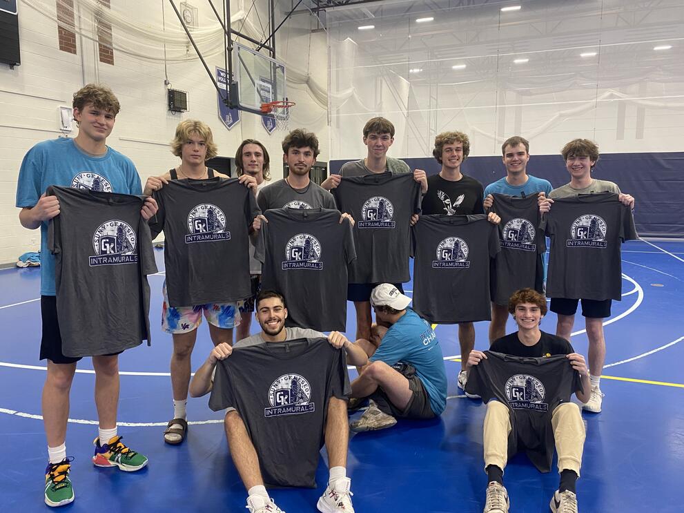 11 volleyball champions holding blue intramural t-shirts.