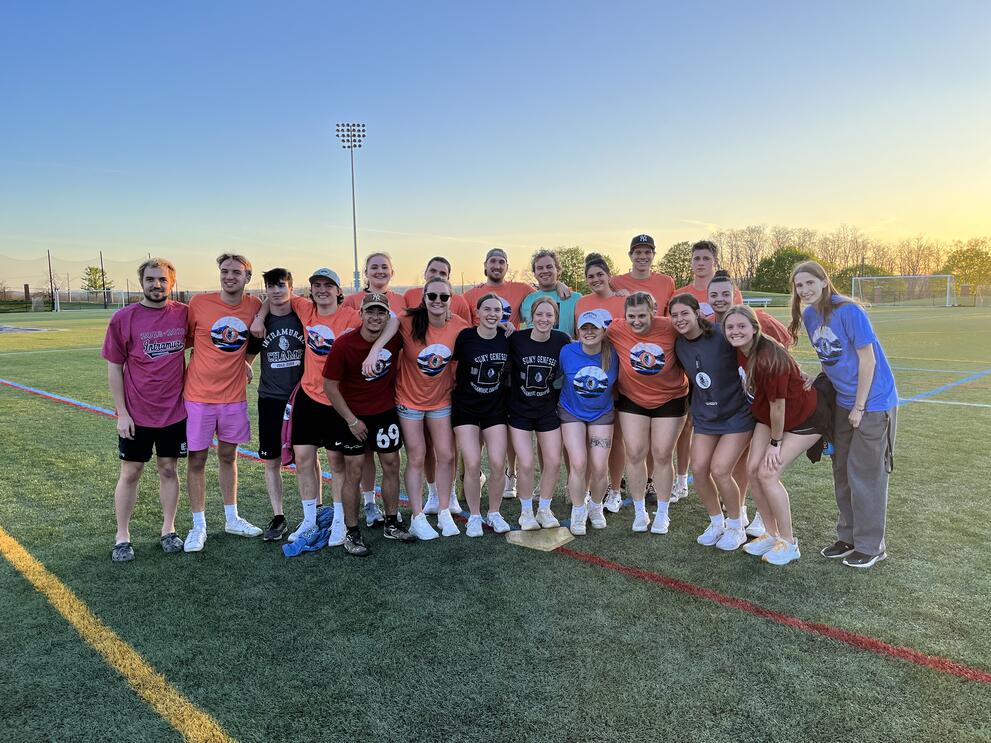 Group of soccer champions wearing orange, black, and blueintramural t-shirts.
