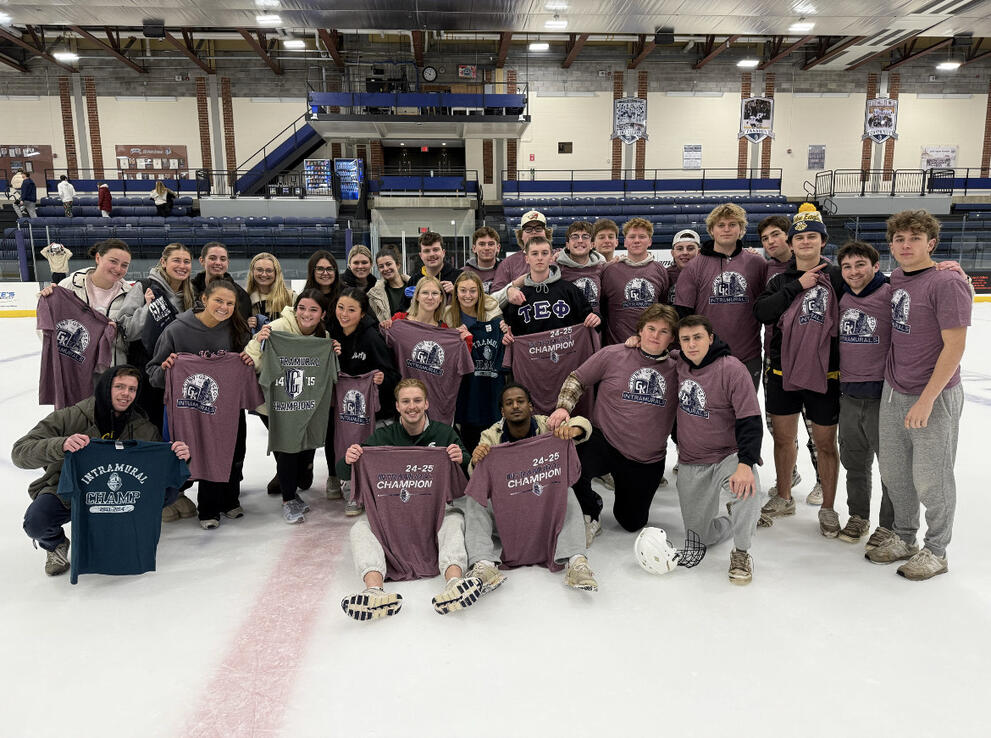 A large group of broomball champions wearing purple intramural t-shirts.