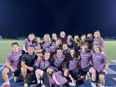 Group of soccer champions holding purple intramural shirts.