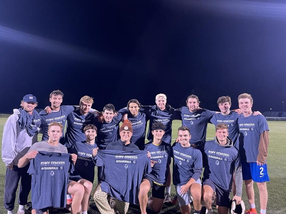 Group of soccer champions holding blue intramural shirts.