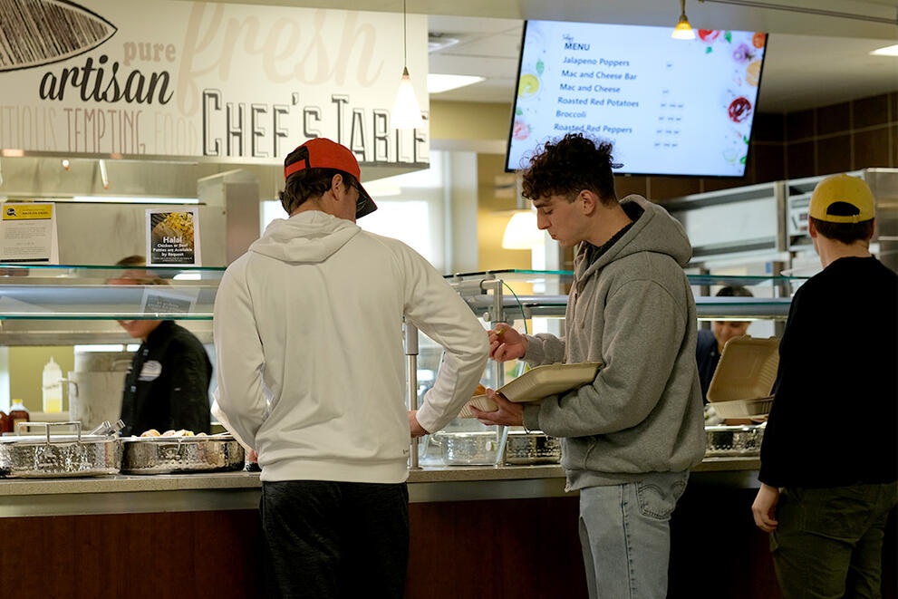 Two students filling their plates at the Chef's Table station in Letchworth Dining Complex.