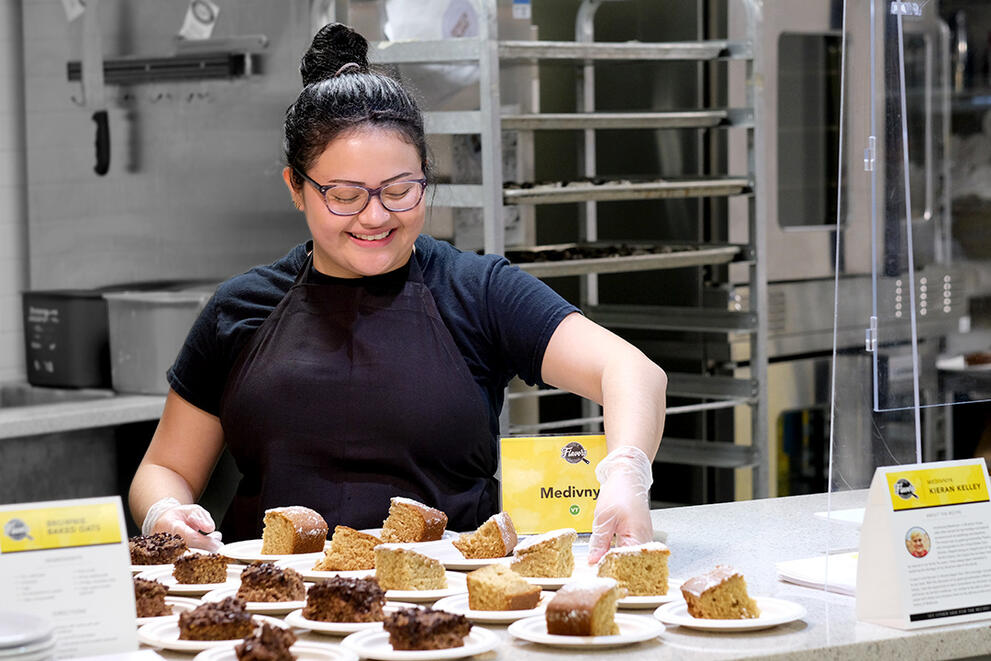 Student employee adds plated desserts to the Streusel station at Letchworth Dining Complex.