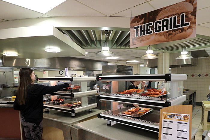 Student getting food at The Grill station in Mary Jemison Dining Complex.