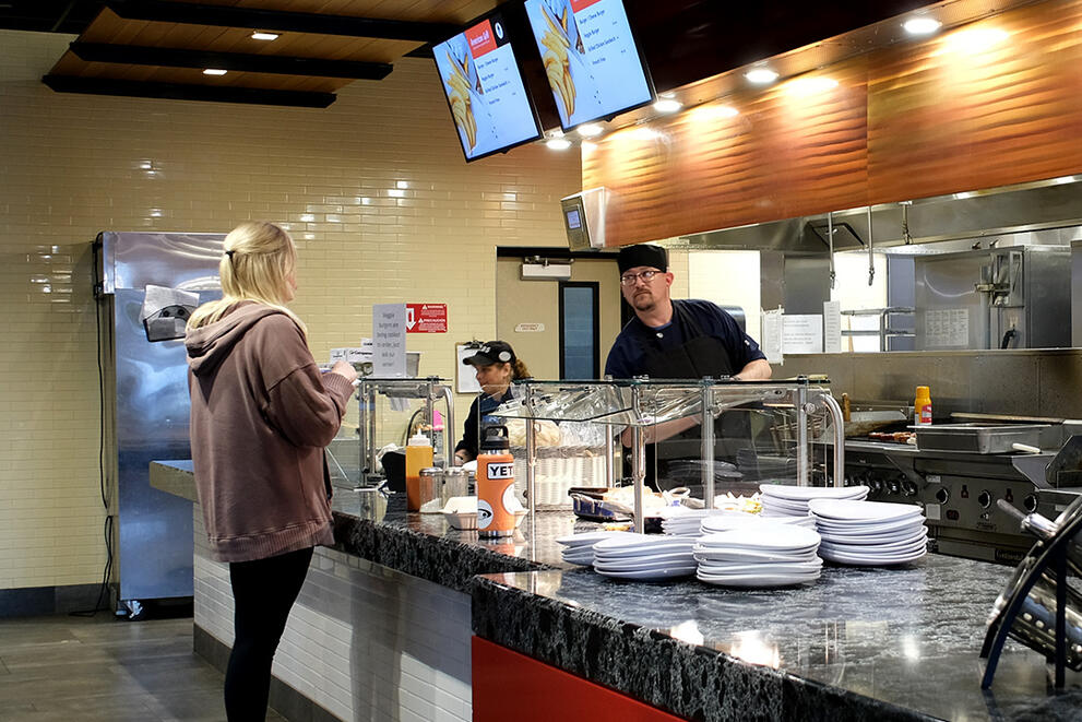 A student orders a custom item at the American Grill in Red Jacket Dining Complex.