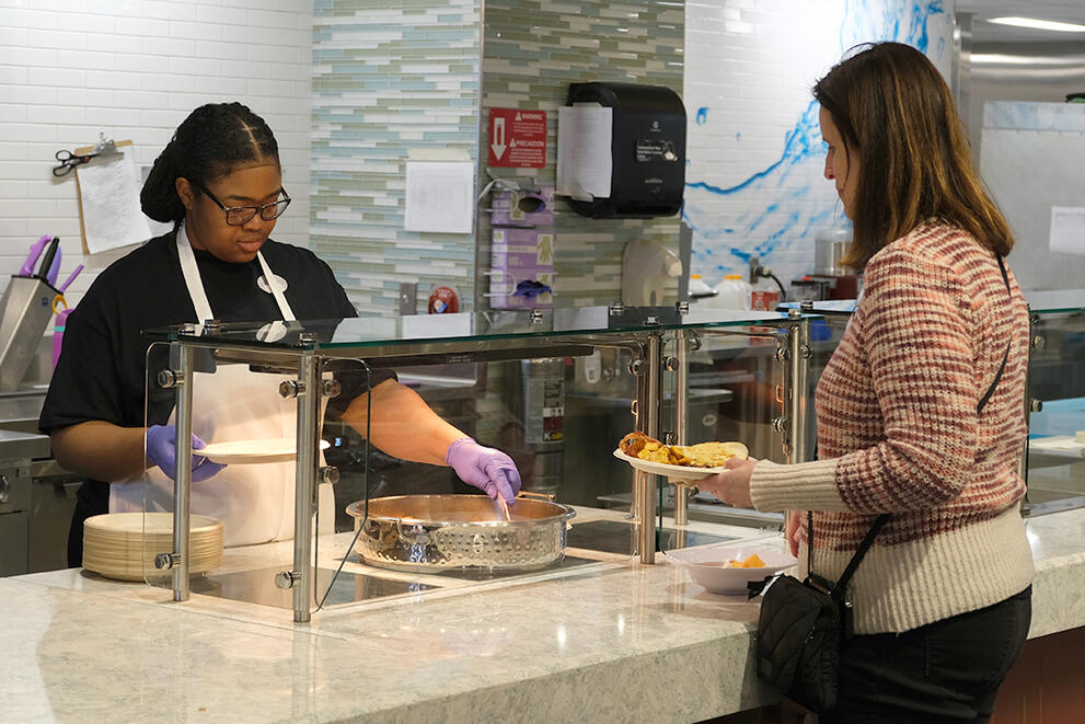 A student employee serves a guest at the Clean Eats station in Red Jacket Dining Complex.