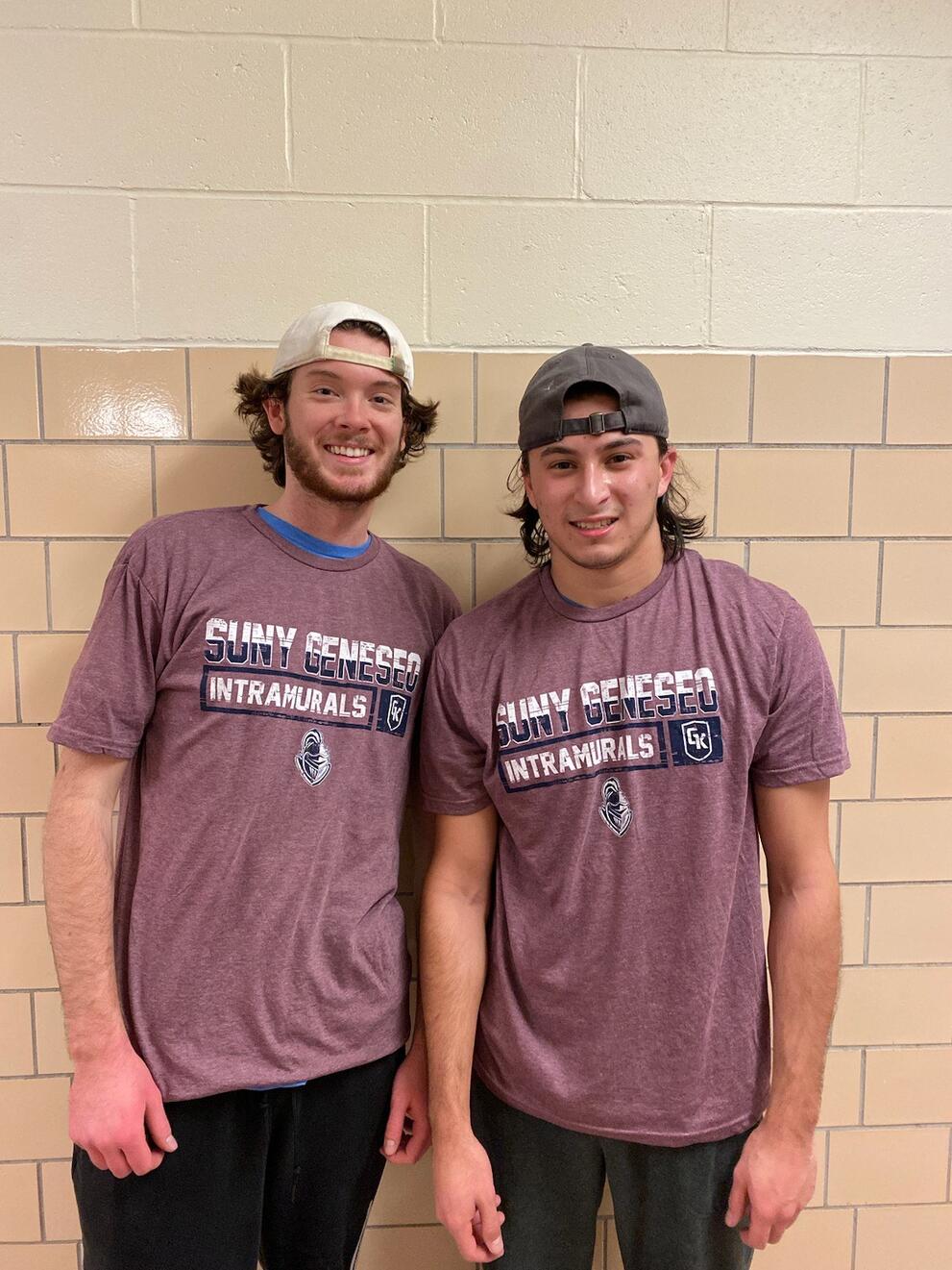 Two spikeball champions wearing purple intramural shirts.