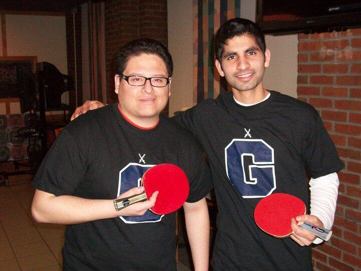 Two students holding ping pong paddles