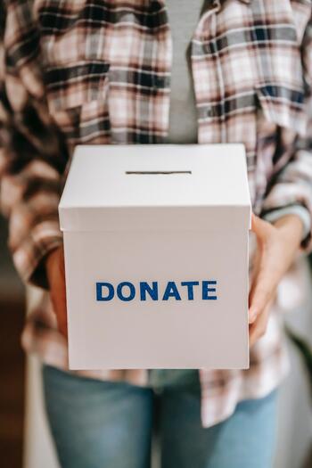 person holding a box marked "donate"