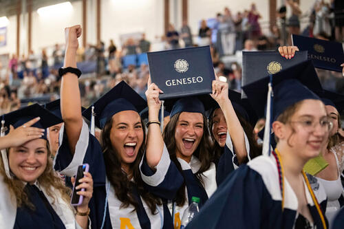 grads holding up diplomas
