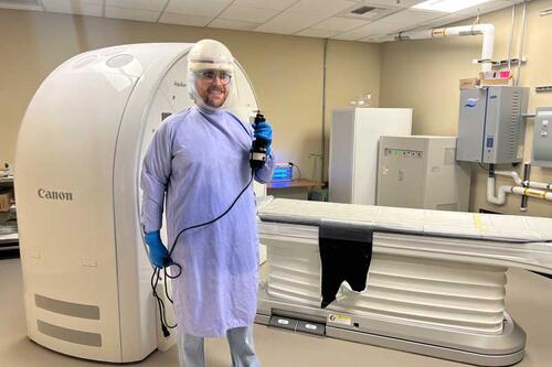 Hunter Kane dressed for autopsy, standing next to CT 