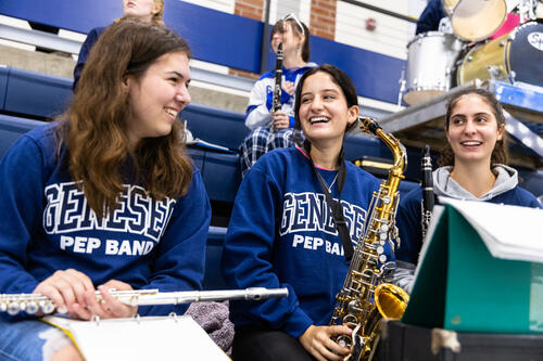 Lainelle Brazee '26 laughs with members of the pep band