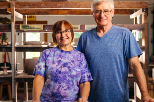 The Lukacs stand in their pottery studio