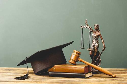 Justice statue with mortarboard, gavel, and books