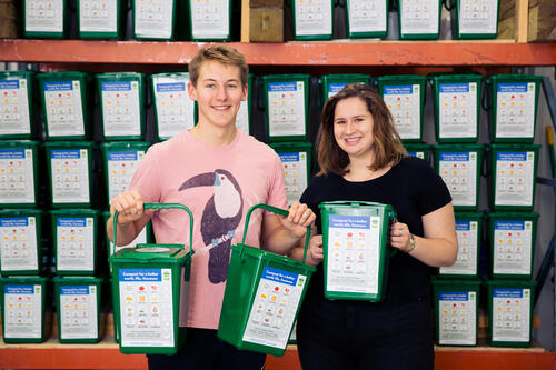 Student interns hold composting buckets used in the program.