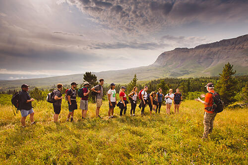 Students listening to Professor Jim Kernan in the Canadian Rockies on a hike.