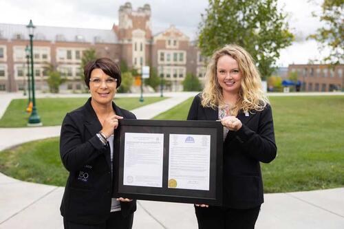 Andrea Klein, director of scheduling, events, and conference services, and Jennifer Gibson, director of donor relations, with the framed proclamations