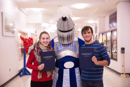 Mallory Colton and Abel Zavitz pose with their letters of acceptance with the Geneseo mascot, a knight.