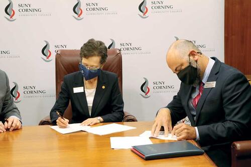 President Denise Battles and Costas Solomou, vice president for enrollment management, sign the SUNY CCC and LECOM agreement