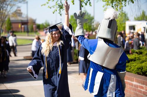 Knight mascot high-fives graduating senior