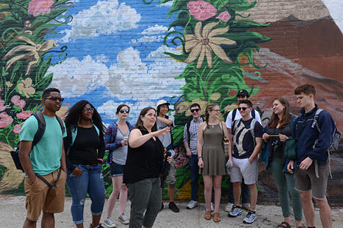 Class in Red Hook, Brooklyn, in front of a mural