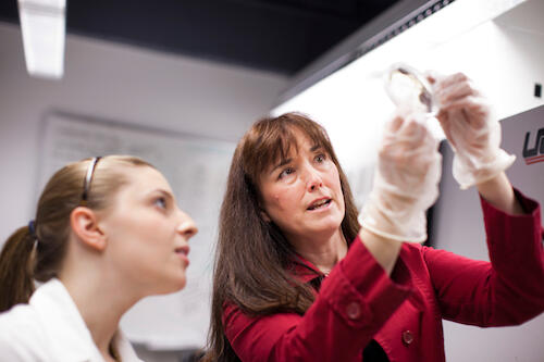 Wendy Pogozelski works in the lab with a student.