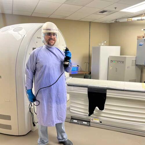 Hunter Kane dressed for autopsy, standing next to CT 