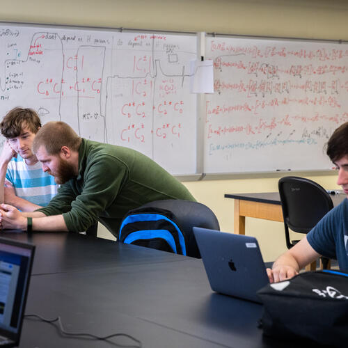 Thomas Osburn, assistant professor of physics and astronomy and two students at a lab.