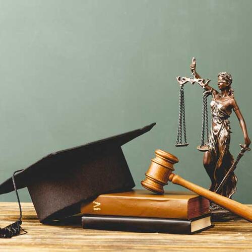 Justice statue with mortarboard, gavel, and books