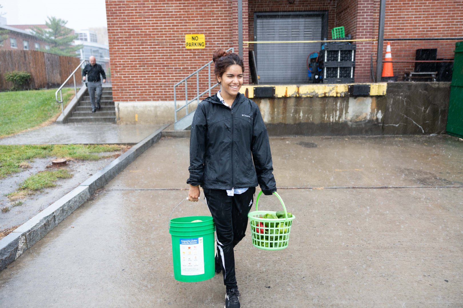Jess Rivera walks to the truck with two buckets full of vegetables.